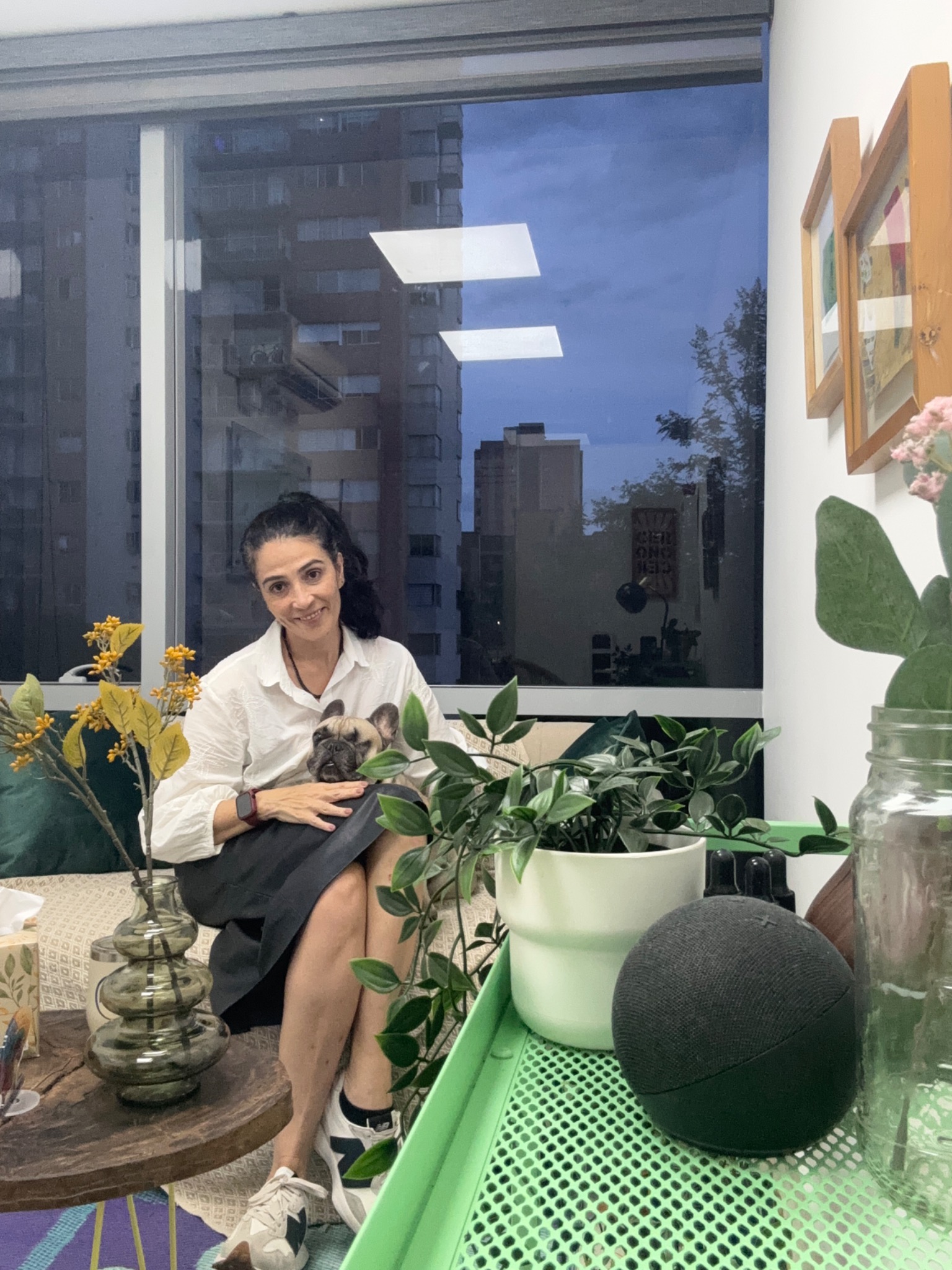 Carolina Gallego Correa sentada con su perro, rodeada de plantas